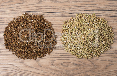 Pile of buckwheat and green buckwheat on wooden background.