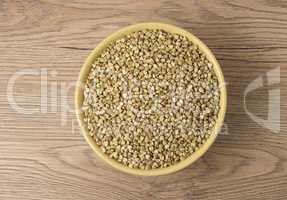 Natural fresh green buckwheat in ceramic bowl on wooden backgrou