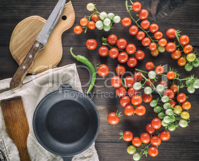 cast iron round frying pan and ripe red cherry tomatoes
