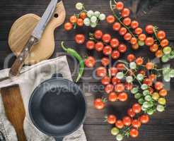 cast iron round frying pan and ripe red cherry tomatoes