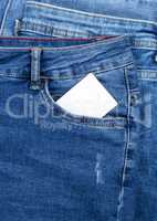 empty white paper card in the pocket of blue jeans
