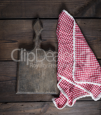 old kitchen cutting board with handle and red towel