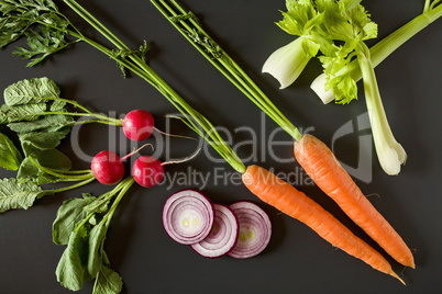 Fresh raw vegetables over a dark background