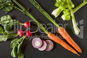 Fresh raw vegetables over a dark background