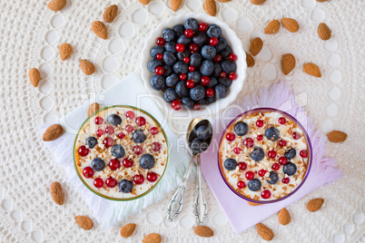 Two yogurt dessert with berries and almonds seen from above