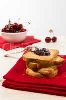 Rusk with cherry jam over a red napkin
