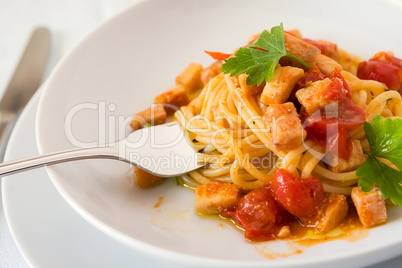 Closeup of spaghetti with fish and little tomatoes