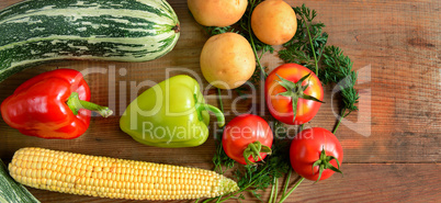 Vegetables laid out on a wooden table. Free space for text. Wide