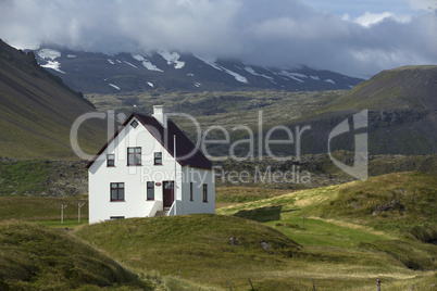 Lonely house at the bottom of mountain, Iceland.