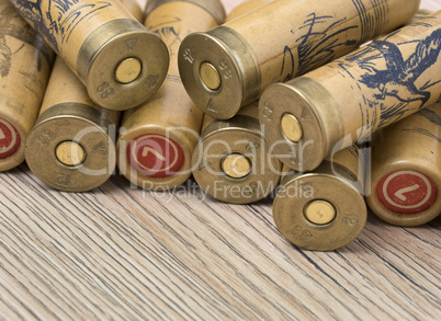 Hunting cartridges of 12 gauge for shotgun on wooden background.