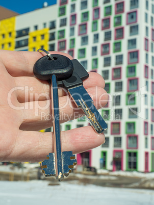 Against the background of a modern apartment building, hand with