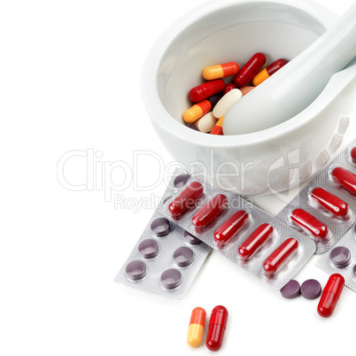 Assortment of medicinal tablets and mortar with pestle isolated