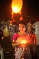 Pune, India - November 2018: A woman lights up a lamp during a p