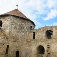 Fortress tower with tiled roof on blue sky background. Location