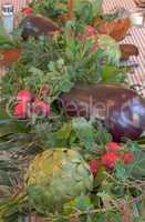 Table decor background of purple eggplant, red radish bushels, a