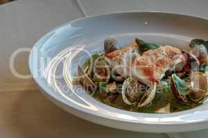 Chilean Sea bass over clams in pesto sauce