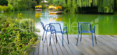 A wooden pier is a platform on a lake in the city park. Wide pho