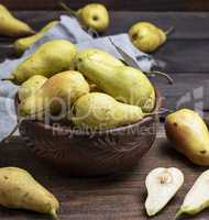 ripe green pears in a brown clay bowl