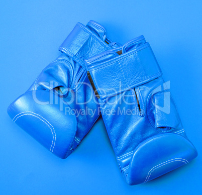 blue sport leather boxing gloves on a red background