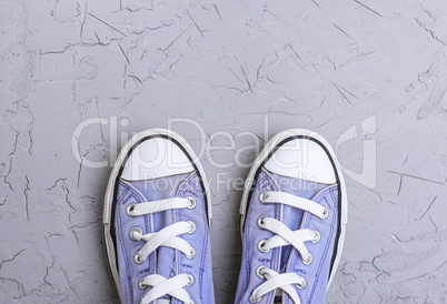 pair of old worn purple  sneakers with white laces