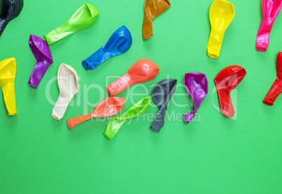 colorful deflated balloons on a green background