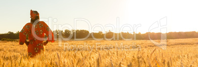 African woman in traditional clothes standing in a field of crop