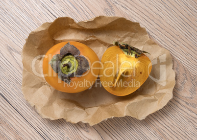 Delicious ripe persimmon fruit on wooden background.