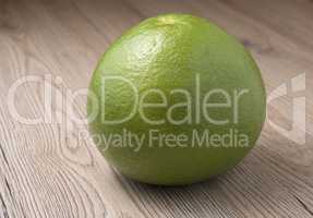 Whole Green Sweetie on wooden background.