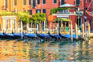 Traditional gondolas by the pier in the channel of Venice