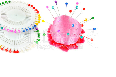 Pillow for needles and bright colored pins isolated on white bac