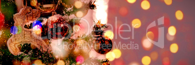 Composite image of defocused of christmas tree lights and fireplace
