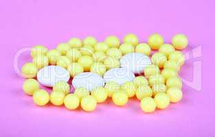 yellow vitamins on pink background