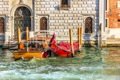 Gondola and a boat in a canal of Venice