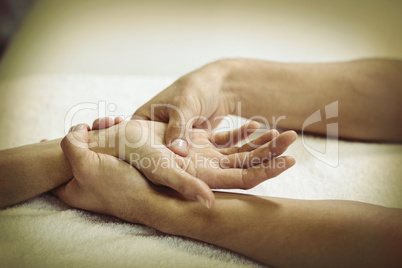 Physiotherapist giving hand massage to a woman