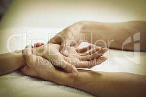 Physiotherapist giving hand massage to a woman