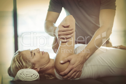 Woman receiving shoulder therapy from physiotherapist