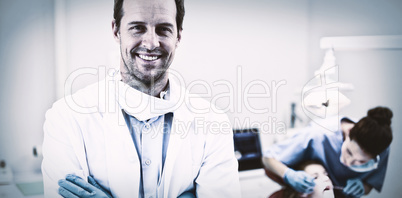 Dentist standing with arms crossed in clinic