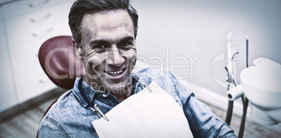 Smiling female patient sitting on dentist chair