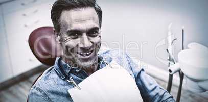 Smiling female patient sitting on dentist chair