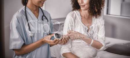 Doctor examining pregnant womans blood sugar