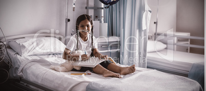 Smiling girl drawing picture in a book