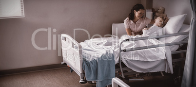 Female doctor consoling patient during visit in ward