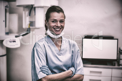 Smiling dental assistant standing with arms crossed