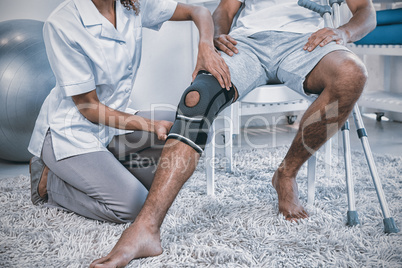 Physiotherapist examining patients knee