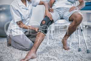 Physiotherapist examining patients knee