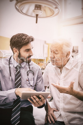 Doctor discussing with patient over digital tablet