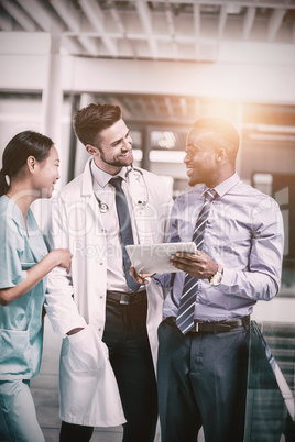 Nurse and doctor having discussion with businessman