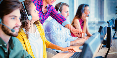 Customer service executive trainer assisting her team Customer service executive trainer assisting her team