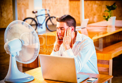 Man enjoying a breeze with laptop on desk