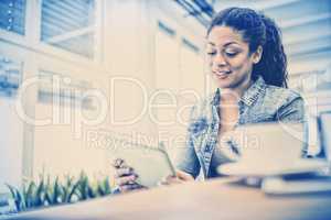 Businesswoman using digital tablet while sitting in creative office